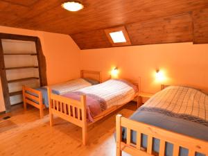 特文Spacious holiday home in Teuven with garden的木天花板客房的两张单人床