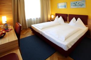 林茨甘梭夫罗瑟玛酒店的卧室配有一张大白色的床和书桌