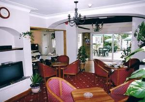 埃普瑟姆绝品公园酒店的一间带桌椅和电视的用餐室