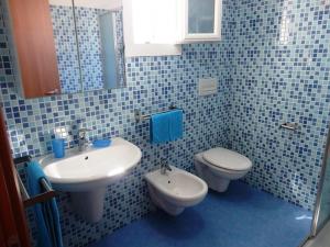 托雷圣乔万尼乌Villetta 3 camere Posto Rosso 155 - Verso Sud的蓝色瓷砖浴室设有水槽和卫生间