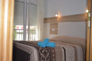 Puente de Vadillos阿玛多尔乡村酒店的一间卧室配有一张带蓝色毛巾的床
