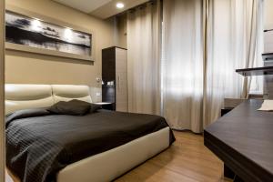 维韦罗内皇家酒店的一间卧室配有一张大床和一张桌子