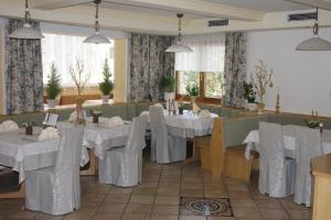 巴德小基希海姆Hotel Sonnenheim的一间设有白色桌椅的用餐室