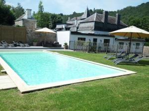 Hastière-par-delàModern Mansion in Hasti re par Del with Pool的房屋旁的游泳池配有椅子和遮阳伞
