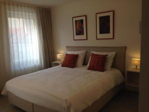 奥斯坦德Comfort Aan Zee Guestrooms的一间卧室配有一张带两盏灯的大型白色床。