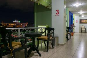 圣萨尔瓦多Hostal de Asturias的餐厅设有带桌椅的阳台