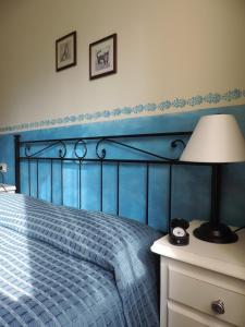 基安蒂格雷夫Chiantirooms Guesthouse的蓝色卧室,配有床和灯