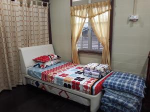 太平奥帕甘文丁旅馆的一间小卧室,配有床和窗户