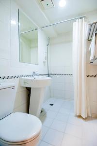 高雄Sanduo Hotel的白色的浴室设有卫生间和水槽。
