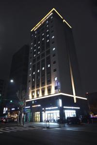 首尔东大门金城大酒店的一座高大的建筑,晚上有标志