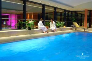 萨格勒布昂特诺维奇萨格勒布酒店的两个女人坐在游泳池旁边