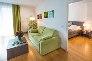 巴特格莱兴贝格费连安库帕克公寓的客厅配有绿色沙发和床。