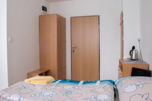 科希策ŠD Urbánkova 2的一间卧室配有一张床、一个衣柜和一个橱柜