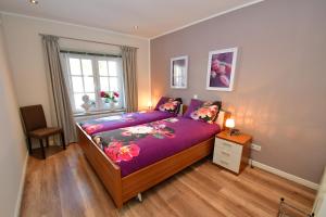 布吕根Ferienhaus Burgblick Brueggen的一间卧室配有一张带紫色床单的床和窗户。