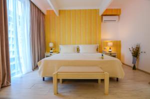 北马马亚-讷沃达里菲尼基豪华酒店的一间卧室设有一张黄色墙壁的大床