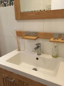 巴黎布尔多内一室公寓的浴室设有白色水槽和镜子