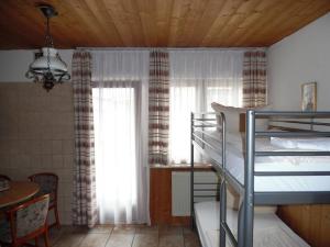 奥伯劳雪绒花酒店的一间卧室设有两张双层床、一张桌子和一个窗口。