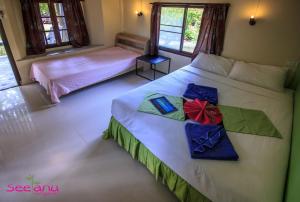 西塔努斯坦努简易别墅酒店的一间卧室配有两张床和礼物