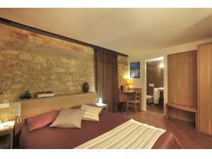 伊塞尔尼亚Residenze Portacastello的一间卧室设有一张带石墙的大床