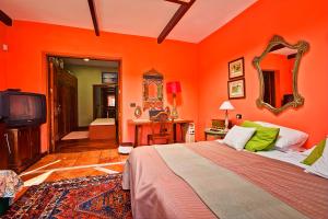 塔科龙特Luxury Villa Golf Tenerife的一间卧室设有橙色的墙壁、一张床和电视