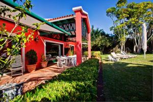 塔科龙特Luxury Villa Golf Tenerife的红色的房子,配有椅子和庭院