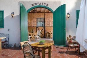 兹奇隆亚科夫Zimer Baronita的一个带桌椅的庭院和一扇绿门
