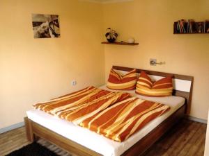 萨加尔德FERIENBUNGALOW Schwanck in Sagard的一间卧室配有橙色和黄色床单