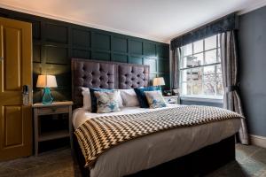埃克塞特城门酒店的一间卧室设有一张大床和一个窗户。
