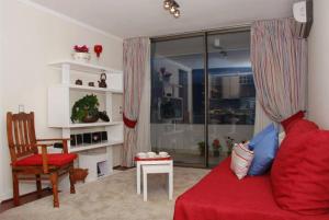 圣地亚哥Puerta Arauco Apartamentos的客厅配有红色的沙发和椅子