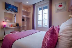 巴黎品客酒店的一间卧室配有带粉红色枕头的床和窗户。