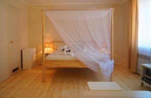 奈达夏日旅馆的一间卧室配有一张带蚊帐的床