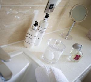 哈尔福德The Old Manor House的浴室水槽配有2瓶肥皂和镜子