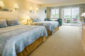 南雅茅斯Surfcomber On The Ocean的酒店客房设有两张床和窗户。