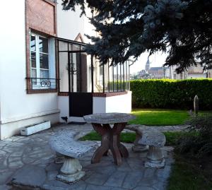 日安Le Repos du Marinier的大楼前的一张石桌和两个长凳