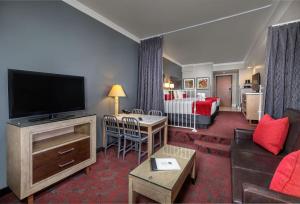 安纳海姆安纳海姆沙漠棕榈酒店及套房的带电视的客厅和配有床的房间