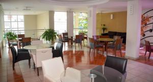 阿瓜斯迪林多亚VOA Plazza Hotel的一间在房间内配有桌椅的餐厅