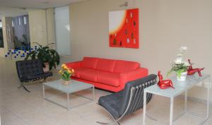 阿瓜斯迪林多亚VOA Plazza Hotel的客厅配有红色的沙发和2张桌子