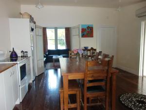 奥玛鲁奥马鲁绿色度假屋的厨房以及带木桌和椅子的用餐室。