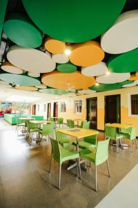 独鲁万塔克洛班酒店的一间食堂,在绿色和白色的天花板下摆放着桌椅