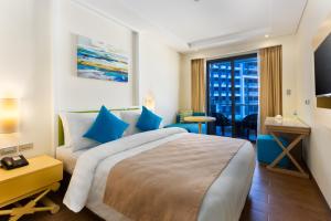 长滩岛长滩岛新海岸萨沃伊酒店的一间设有大床和窗户的酒店客房
