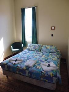 彭古因快乐背包客酒店的卧室配有床、椅子和窗户。