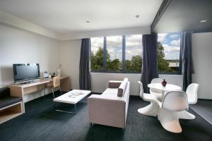 布莱克敦东克里克阿尔法酒店的客厅配有白色家具和大窗户