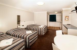 土乌巴杰弗里斯汽车旅馆的酒店客房设有两张床和一张桌子。