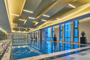 上饶上饶万达嘉华酒店的一座带窗户的建筑中的游泳池