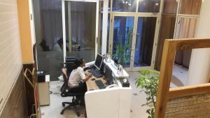 亚的斯亚贝巴C Fun Addis Hotel的办公室,有两个人坐在桌子上,电脑