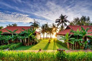 富国富国岛盛泰乐精选晨曦水疗及度假村的一座红色屋顶和棕榈树的房子