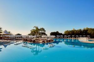 普罗塔拉斯格雷西安公园酒店的一个带椅子和遮阳伞的大型游泳池