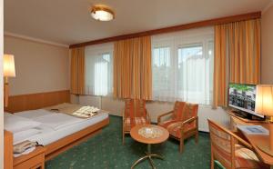巴特哈尔哈勒霍夫酒店的酒店客房带一张床、一张桌子和椅子