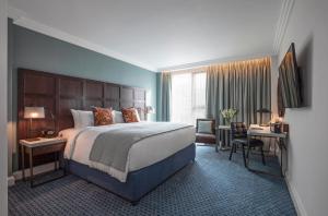 剑桥Clayton Hotel Cambridge的酒店客房设有一张大床和一张书桌。
