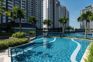 普特拉贾亚Palm Armada Residence Free Parking and Netflix的一座棕榈树和建筑的大型游泳池